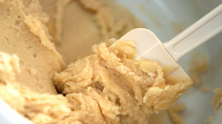 close up of a spatula in a bowl of cookie dough